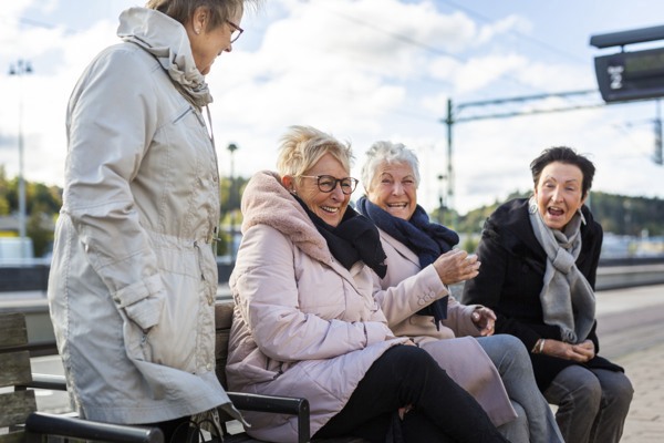 Fyra glada pensionärer på en perrong